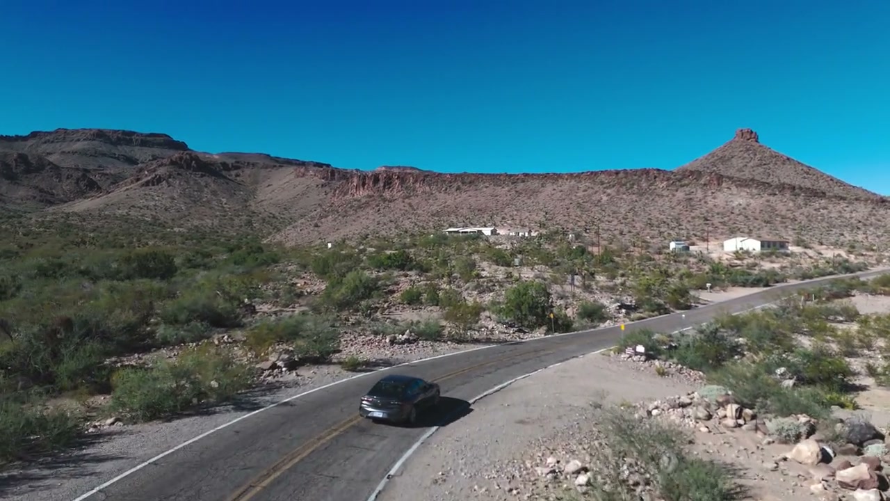 Aerial drone shot of a car on a desert road