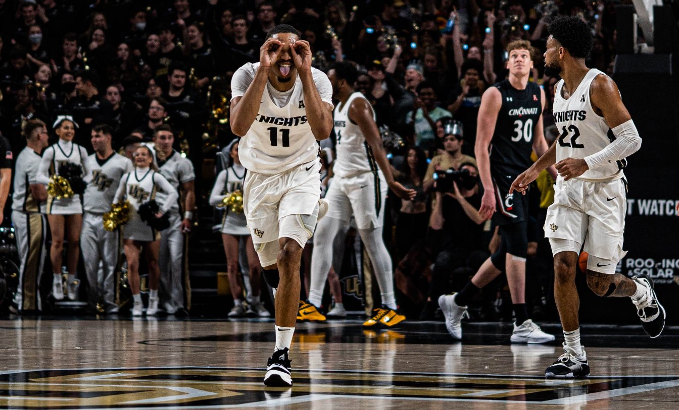UCF Knights player celebrating a three with goggles gesture against Cincinnati