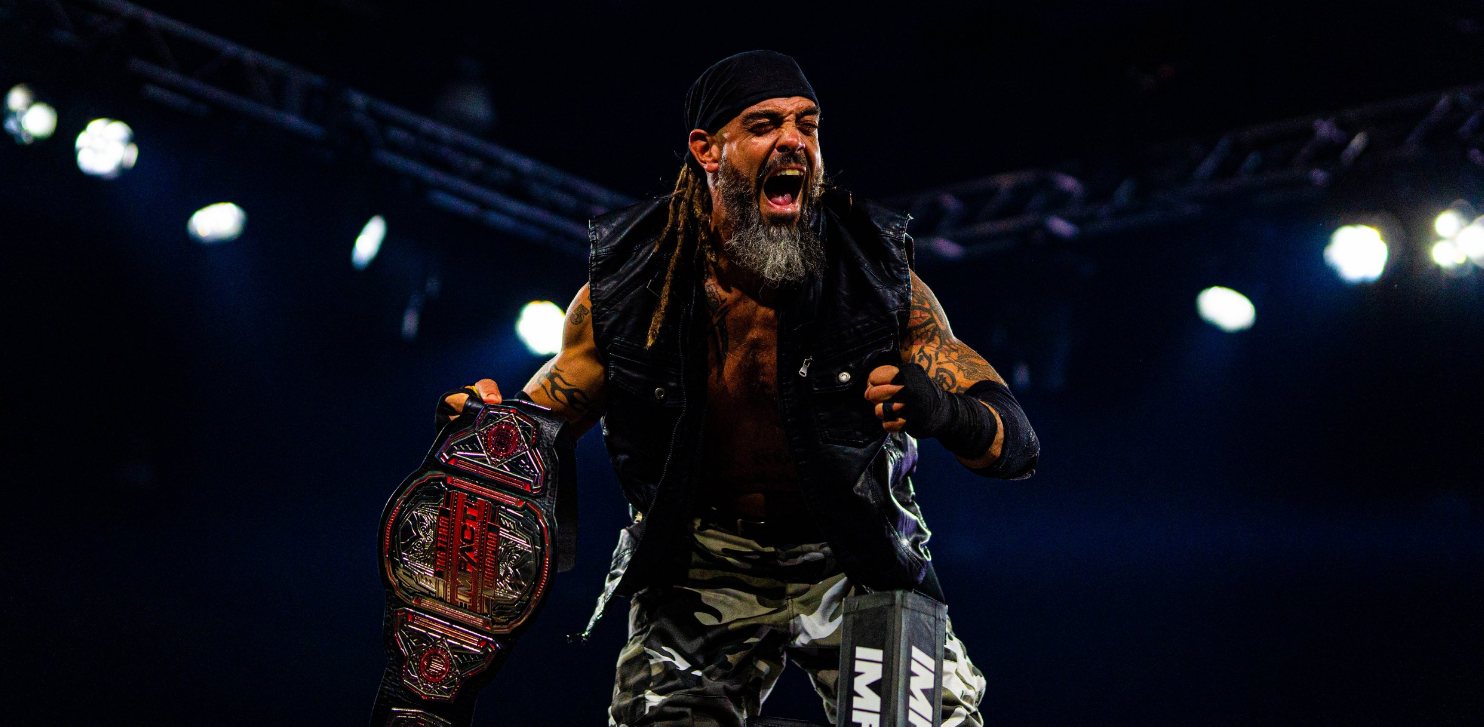 Wrestler screaming with a championship belt in hand under arena lights
